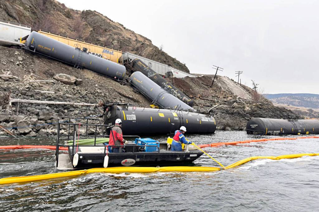 Rail cars on the bank and in the water of Kamloops Lake, with containment booms in the foreground, pictured on Nov. 3, two days after a derailment on the CPKC mainline near Savona. (Michael Grenier)